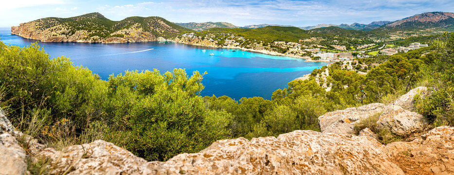 Elevated view from Cap Andritxol over tourist resort Camp de Mar bay with peninsula Cap des Llamp, cove Cala Blanca and Cala en Cranc and Camp de Mar beaches in front of Serra de Tramuntana mountains.