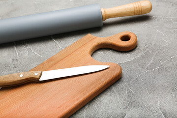 rolling pin and cutting board on cement background