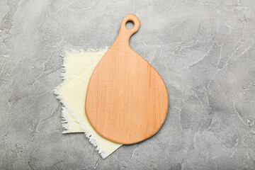 cutting board with a light towel on a cement background. top view
