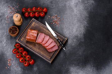 Delicious smoked meat cut with slices on a wooden cutting board