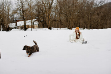 portrait of a woman outdoors in a field in winter walking with a dog Lifestyle
