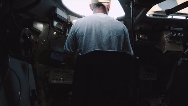 A military driver of a combat vehicle looks at the road
