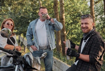 Meeting A company of friends of motorcyclists bikers on motorcycles stopped on the roadside having fun and drinking tea