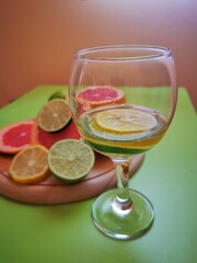 Slices of citrus fruits in glass of cocktail. Grapefruits, lime and lemon in refreshing sparkling drinks with bubbles