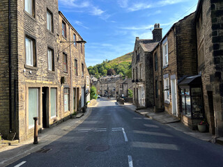 Fototapeta na wymiar Looking down the, High Street, with old shops and cottages, in the picturesque village of, Delph, Oldham, UK