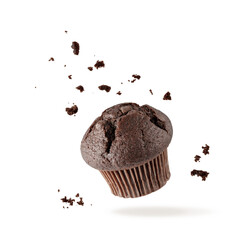 Fresh baked single chocolate muffin with crumbs flying on white background. Sweet dark cupcake falling. - obrazy, fototapety, plakaty