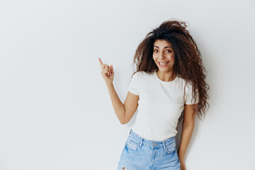FASHION SUMMER SALE OFFER. Cheerful, smiling curly Latin female stay near green wall, say Yeah, show at free place copy space, cool ad for clothes sales. Studio shoot isolated, over white background