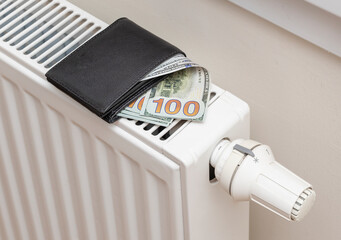 dollar banknotes on central heating radiator, the concept of expensive heating costs, front view