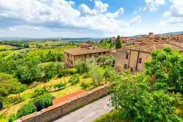 Fototapeta na wymiar View of the hills, vineyards and countryside from a terrace above typical Tuscan stone homes in the medieval hill town of San Gimignano, Italy.