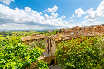 View of the hills, vineyards and countryside from a terrace above typical Tuscan stone homes in the...