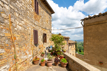 Plakat A small residential terrace along the outer wall of the Tuscan hill town of San Gimignano, Italy.