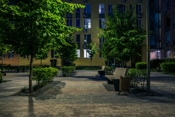 Night park paths and colored houses at summer night. Night paths, benches and lanterns in a beautiful residential complex. Night summer park with lanterns and benches. Kyiv. Ukraine