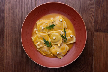 Pasta rellana, raviol ravioles con salsa naranja