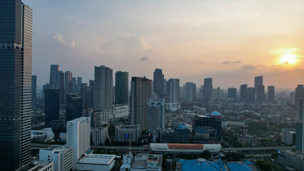 Naklejka na ściany i meble Aerial view of office buildings in Jakarta central business district and noise cloud when sunset.