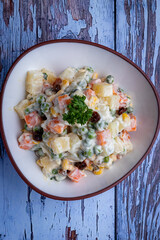 Ensalada rusa sobre fondo madera