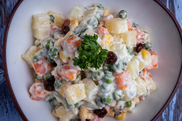 Ensalada rusa sobre fondo madera