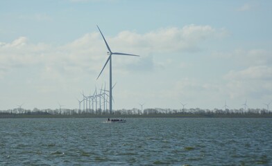 Offshore wind turbines at Amstelmeer, Netherlands. 
 Dutch windmill park in the North sea. Space for text. 
