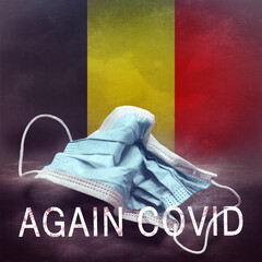 Inscription Again Covid and a crumpled medical mask on the flag of Belgium. Return of the...