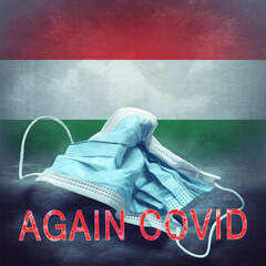Lettering Again Covid and a crumpled medical mask on the flag of Hungary. Return of the...