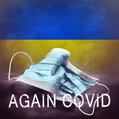 Inscription Again Covid and a crumpled medical mask on the flag of Ukraine. Return of the...