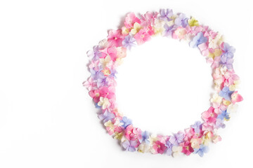 Round circle frame made of small multi-colored hydrangea flowers isolated on a white background. Flat lay, top view