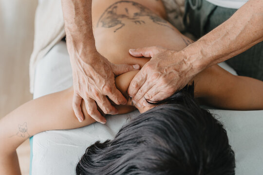physiotherapist massaging a woman's lower neck