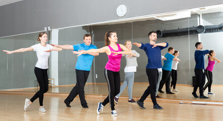 Group of adult people training in gym, doing aerobics exercises