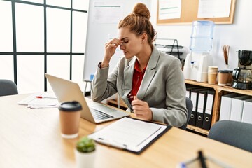 Young woman business worker stressed using laptop working at office