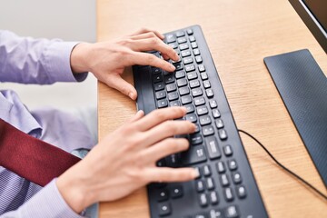 Young hispanic man business worker touching computer keyboard working at office