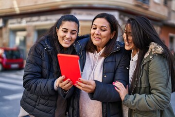 Three woman mother and daughters having video call at street