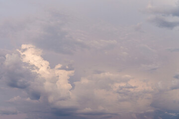Fantastic cloudy sky replacement background at sunset with fluffy and textured clouds with white, pink, blue and purple tones.