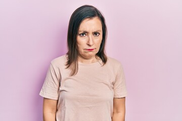 Fototapeta premium Middle age hispanic woman wearing casual clothes skeptic and nervous, frowning upset because of problem. negative person.