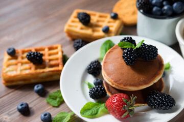 Pancakes for breakfast with blackberries and strawberries.