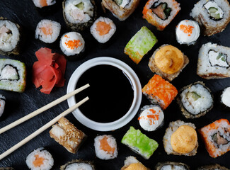 Set of sushi and maki on stone table.