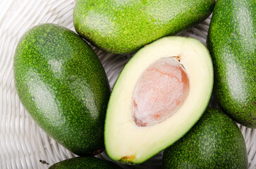 sliced ​​avocado on a background of green avocados