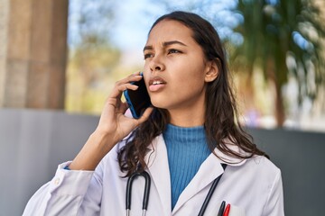 Young african american woman doctor talking on the smartphone at street