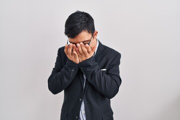Young hispanic man with down syndrome wearing business style with sad expression covering face with...