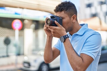 Fototapeta na wymiar African american man using professional camera at street