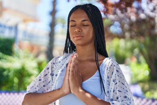 African american woman smiling confident praying at park