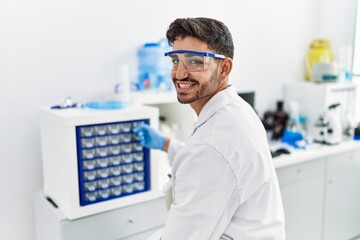 Handsome hispanic man working as scientific at laboratory