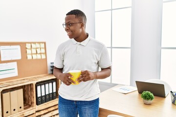 Young african man working drinking a coffee at business office