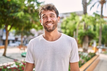 Young hispanic man smiling confident walking at park