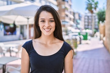 Young hispanic girl smiling happy standing at the city.