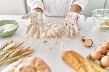 Young woman wearing cook uniform kneading flour at kitchen