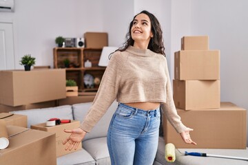 Young hispanic woman smiling confident standing with open arms at new home