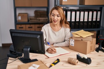 Young woman ecommerce busines worker writing on notebook at office