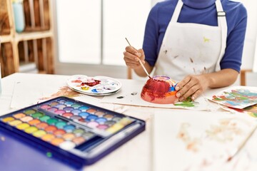 Fototapeta premium Young latin woman painting clay ceramic at art studio