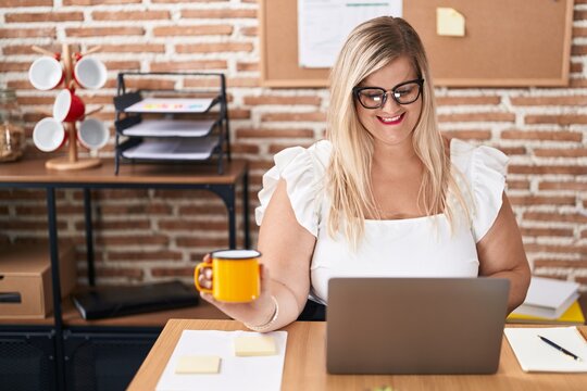 Young woman business worker using laptop drinking coffee at office