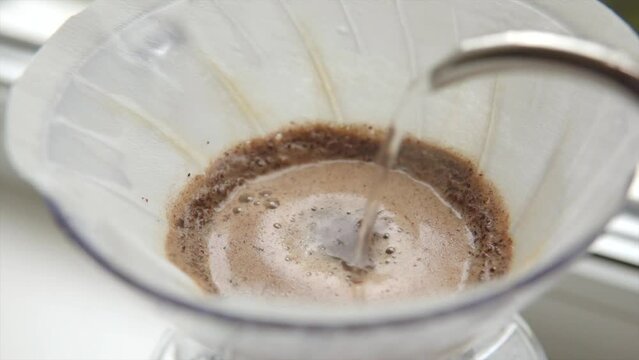 Barista pours water into the filter with coffee, brewing alternative coffee