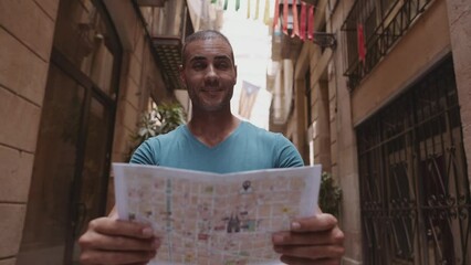 Happy male tourist maps user walking in old town alley an using a map. Barcelona, Spain. Cinematic 4K